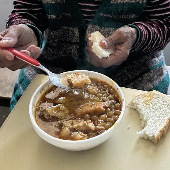 Someone eating hot soup and bread