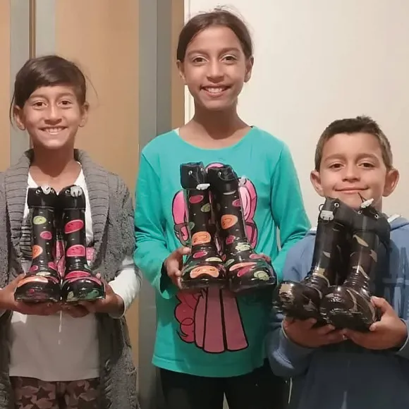 Three children grateful to receive new wellington boots