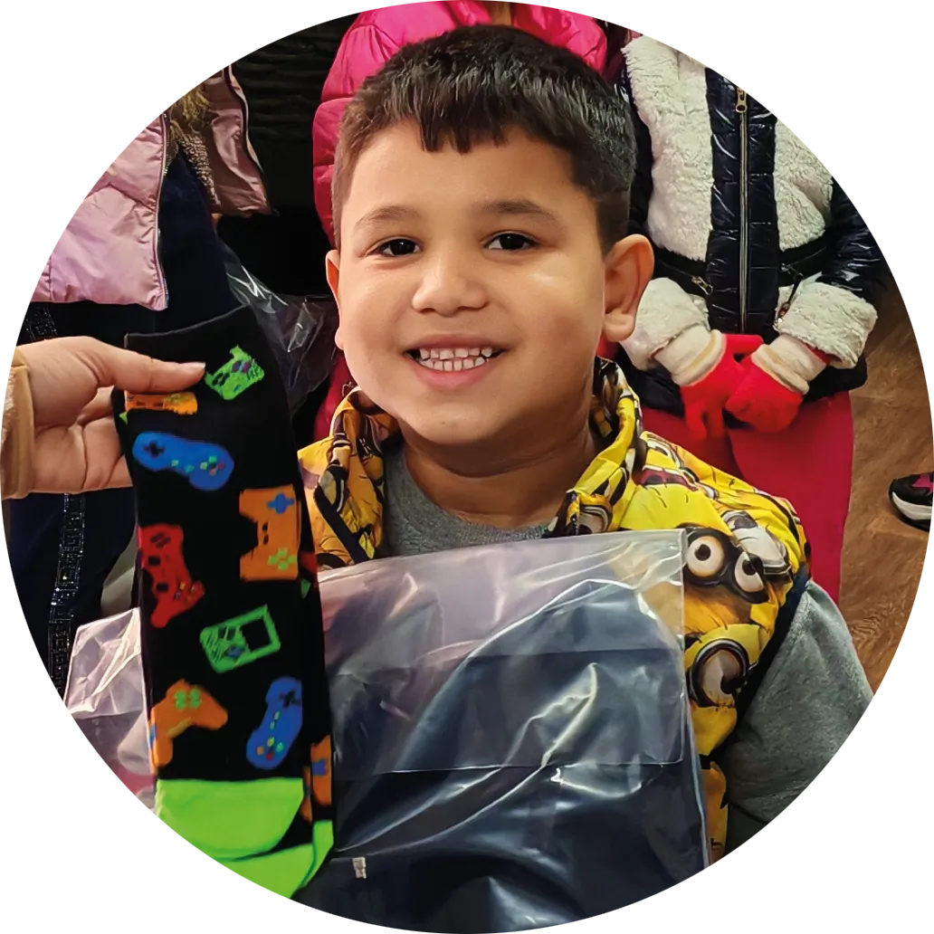 Happy boy receiving clothing gifts through WinterHelp support